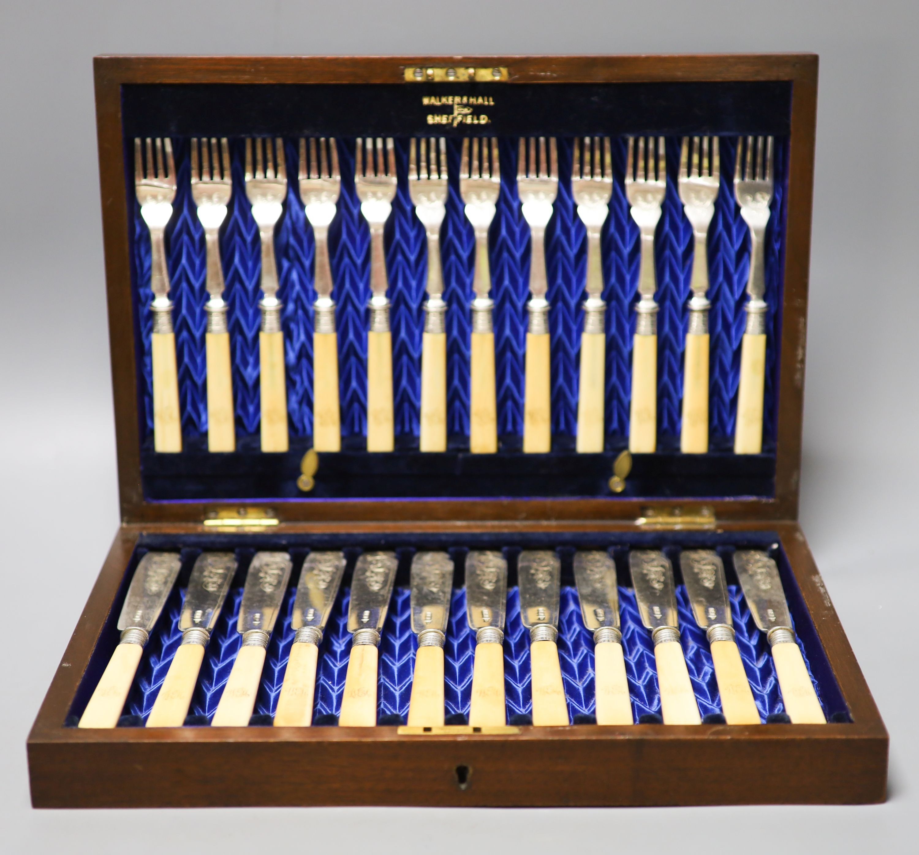 An Edwardian cased set of twelve pairs of ivory handles silver fish eaters, Walker & Hall, Sheffield, 1903.